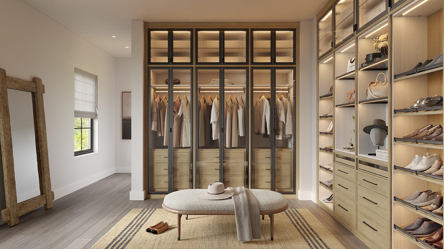 Elegant walk-in closet with wooden shelving, glass doors, hanging clothes, shoes, accessories, and a cushioned bench under soft lighting
