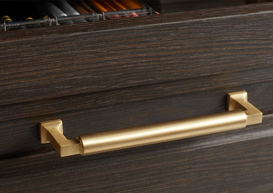 Wood grain finish with decorative hardware, shown in gold by California Closets