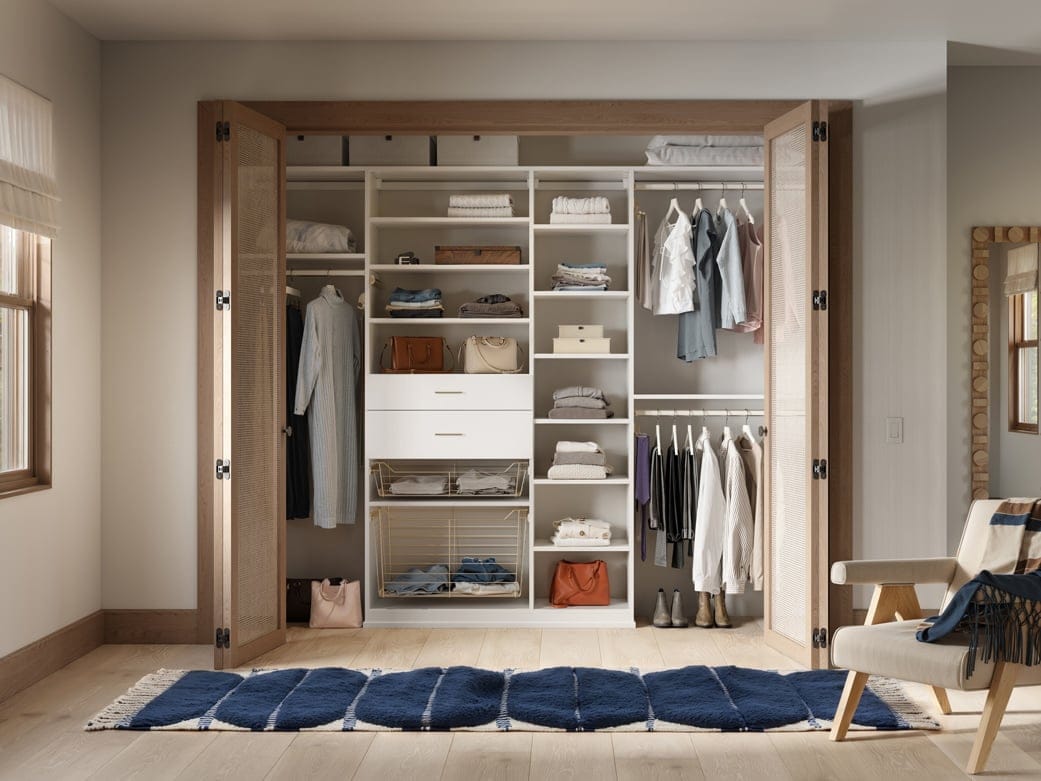 Designed with cubbies and reach in closet, to-floor shelving, and open shelving by California Closets